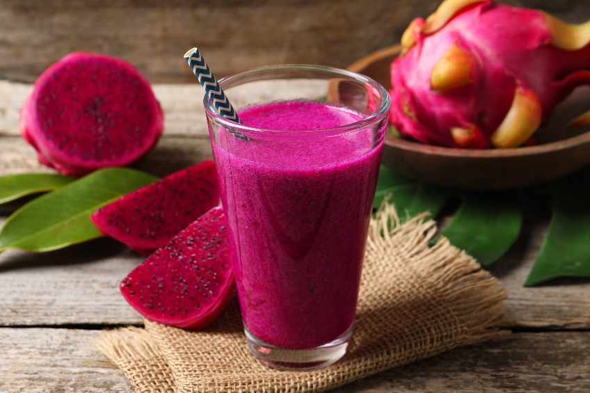 Glass of tasty pitahaya smoothie and fresh fruits on wooden table ...