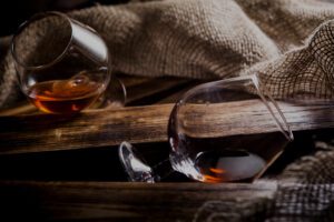 photo glasses of whiskey or cognac on a wooden background