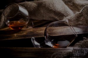 photo of glasses of whiskey or cognac on a wooden background
