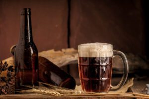 photo of a beer bottle and Still Life with a draft beer by the glass on wooden table