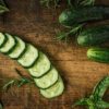 green fresh farm edible sliced cucumbers with basil and rosemary | Puree Arete photo of cucumbers on wooden board