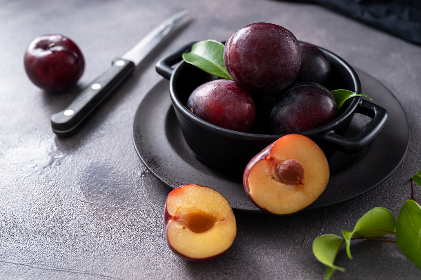 Fresh cherry plum fruits in black bowl dark and moody food photo | Puree Arete fresh plums for fruit puree photo