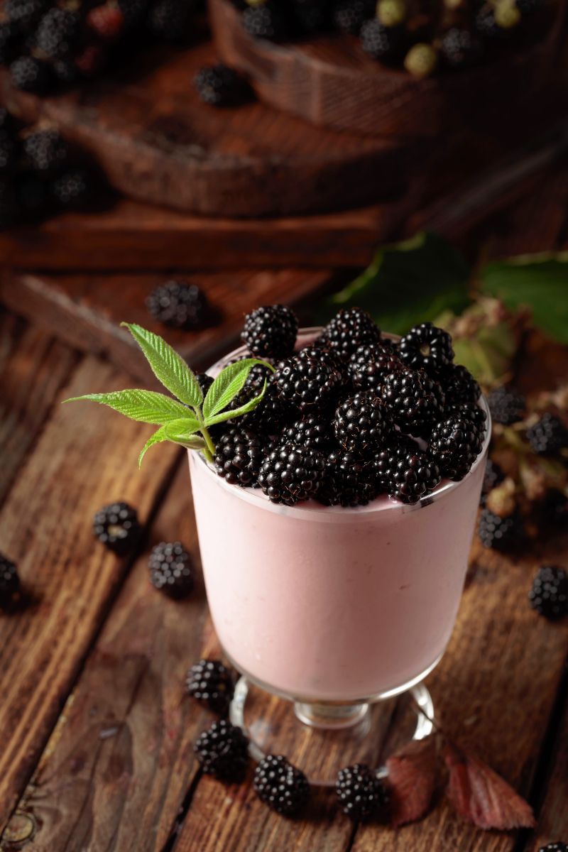 Blackberry yogurt and fresh juicy berries on an old wooden table | Puree Arete Blackberry and vanilla pairing for dessert product development